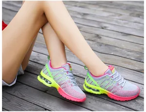 Detailed close-up view of grey and pink women's breathable sneakers on a wooden deck