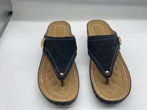 Detailansicht dunkelblauer Zehentrenner-Sandalen mit Durchbruchmuster und Plateausohle