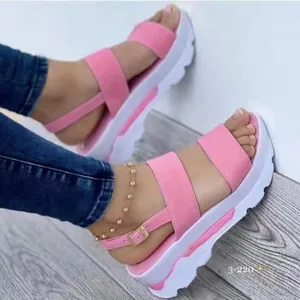 Dettaglio delle scarpe con zeppa rosa con cinturino doppio e fibbia regolabile
