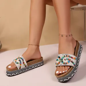 Primer plano de sandalias étnicas de plataforma con cuentas de colores y perlas.