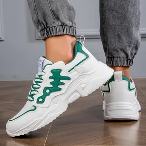 Detailed view of stylish white men's chunky sneakers with green accents and mesh panels.