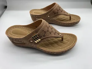Detailansicht brauner Keil-Zehentrenner mit eleganten Lochmustern und Goldakzenten