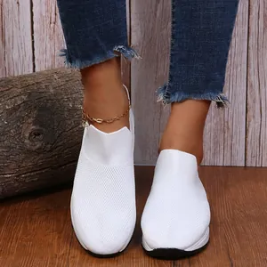 Gros plan de baskets de course en maille respirante blanche pour femmes sur bois