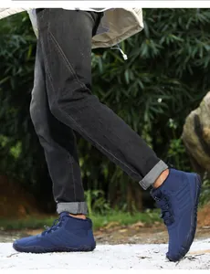 Close-up view of blue warm snow boots being worn outdoors for winter hiking and trekking.