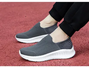 Detailed view of grey fly-knit slip-on walking shoes with thick white wavy soles