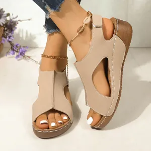 Detailweergave van stijlvolle beige sleehak sandalen met mooie stikseldetails.