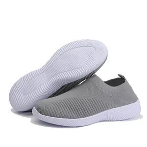 Detail showing breathable flyknit texture and non-slip white outsole of the grey sneaker.