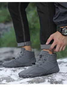 Detailed view of grey barefoot snow boots with warm fleece lining on snow surface.