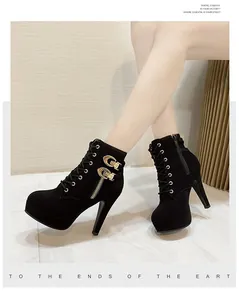Détail de bottines à plateforme et talons hauts noirs avec boucles dorées et lacets