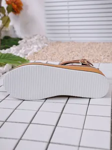 Vue détaillée de la semelle plateforme blanche antidérapante d'une chaussure compensée.