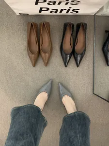 Vista detallada de zapatos de tacón bajo trenzados con punta en tonos marrón y negro