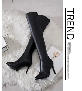 Elegant black over-the-knee pointed-toe stiletto boots displayed on a white plush rug