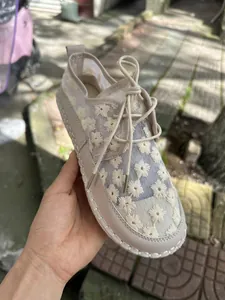 Detailed view of women's summer mesh lace casual shoes with white floral embroidery patterns