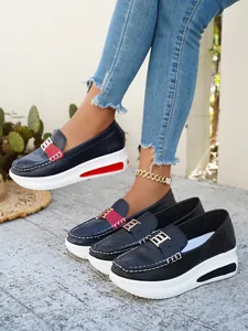 Close-up of stylish women's platform loafers with round toe and gold metal buckle.