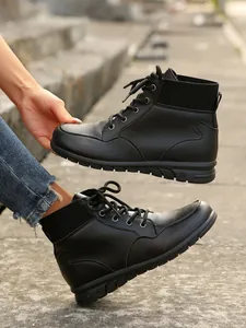 Detailed view of black retro lace-up ankle boots with ribbed collar and thick sole.