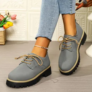 Side detail view of grey lace-up platform loafers featuring a round toe and block heel