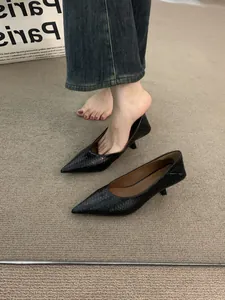 Primer plano de la textura tejida negra en elegantes zapatos de tacón bajo en punta