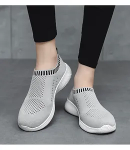 Detailansicht der atmungsaktiven grauen Fly-Knit-Textur und der flexiblen weißen Sohle.