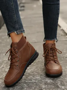 Detailed view of women's retro brown lace-up ankle boots with a thick black rubber sole.