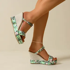 Detailansicht von Keilsandaletten mit Blumenmuster und Espadrille-Absatz für Damen.