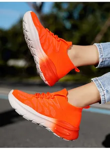 Close-up of bright orange flyknit sock sneakers on feet with outdoor blurry background