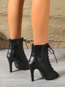 Close-up view of elegant black lace-up peep-toe high-heel dance boots for women.
