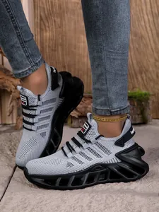 Vue détaillée de baskets en maille grise avec semelle noire amortissante et ajourée