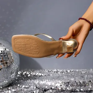 Detailed view of the non-slip sole and low heel on a gold flip-flop sandal