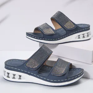 Detail view of blue wedge slippers with sparkling rhinestone straps and air cushion sole.