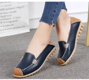 Close-up of navy blue pebbled leather loafers with stylish brown accents and stitching.