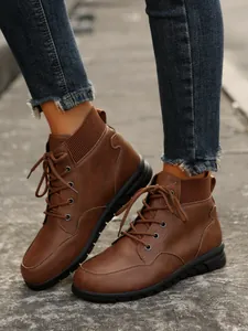 Detailed close-up shot of women's brown lace-up platform Martin boots worn on street