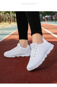 White breathable fly-knit women's lightweight sports sneakers shown on a running track