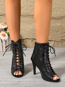 Close-up detail of black peep-toe lace-up stiletto ankle boots for jazz dance fashion