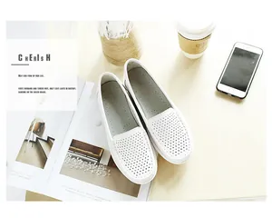 Stylish white perforated leather comfort loafers for women on a cozy lifestyle desk setup