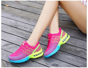 Vibrant pink women's sports running shoes with colorful EVA sole shown worn on wooden deck