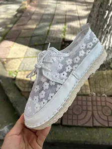 Detailed view of white mesh lace casual shoes featuring floral embroidery and jute soles