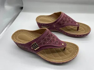 Detailansicht der weinroten Damen-Keilsandalen mit modischem Lochmuster und Goldakzenten