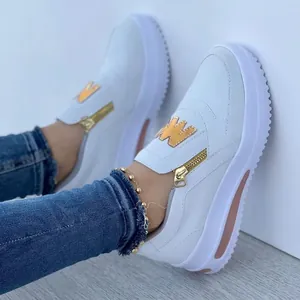 Detail view of white platform sneakers for women with gold zipper and W emblem