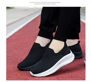 Close-up of black fly-knit slip-on sneakers with white lightweight EVA foam soles