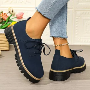 Detailed side and rear view of navy blue suede lace-up platform shoes on model feet