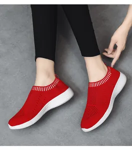 Nahaufnahme atmungsaktiver roter Slip-On-Sneaker aus Strick für Damen am Modellfuß.