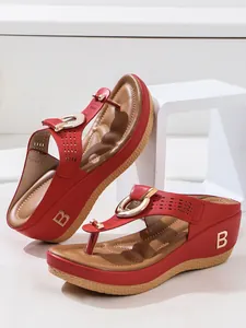 Detailed side view of red wedge flip-flop sandals featuring a gold B logo on the heel.