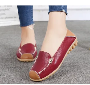 Detail view of stylish women's red and tan leather loafers featuring white contrast stitching