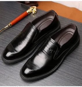 Vue rapprochée du cuir fin et du logo libellule sur des mocassins de ville noirs pour hommes