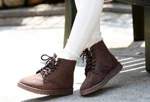 Detail view of brown suede winter ankle boots with warm white faux fur lining and lace-up