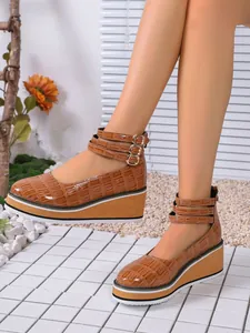 Vue détaillée de chaussures à semelles compensées en cuir verni marron à motif crocodile