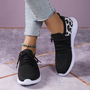 Close-up of black mesh lace-up sneakers featuring a stylish leopard print heel detail