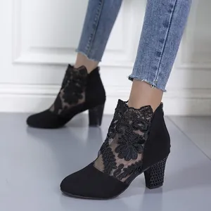 Detailed view of women's black lace mesh ankle boots with chunky heels and floral embroidery