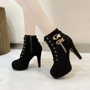 Bottines élégantes à talons hauts noirs avec boucles dorées et fermeture éclair latérale.