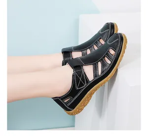 Nahaufnahme von schwarzen Retro-Ledersandalen für Damen mit weicher Sohle und Klettverschluss